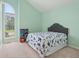 Bright bedroom with peaked ceiling and large window, carpeted floor, and pale green walls at 430 Oakbrook Dr, Columbus, IN 47201