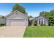 Inviting single-story home with attached garage, lush lawn, and delightful landscaping at 430 Oakbrook Dr, Columbus, IN 47201