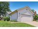 Angle view of home featuring two-car garage, manicured lawn, and tidy side entry at 430 Oakbrook Dr, Columbus, IN 47201