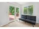 Bright sitting room with a futon and doors leading to the wooden deck and backyard at 430 Oakbrook Dr, Columbus, IN 47201