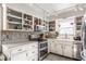Cozy kitchen boasts white cabinets, mosaic backsplash, stainless appliances, and ample counter space at 48 Wilson Dr, Carmel, IN 46032
