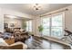 Bright living room featuring hardwood floors, large windows, and open layout into the cozy sitting area at 48 Wilson Dr, Carmel, IN 46032