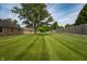 Expansive backyard with lush green lawn and a privacy fence, ideal for outdoor activities at 5032 Monticello Dr, Columbus, IN 47203