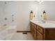 Bright bathroom featuring a tub-shower combo and a wooden double sink vanity at 5032 Monticello Dr, Columbus, IN 47203