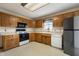 Functional kitchen with white appliances, light countertops, and wooden cabinets at 5032 Monticello Dr, Columbus, IN 47203