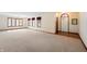 Spacious living room with neutral carpet, multiple windows, and a view of the front door at 5032 Monticello Dr, Columbus, IN 47203