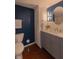 Modern bathroom with a blue accent wall, elegant vanity, and updated fixtures at 5609 Meadowood Dr, Indianapolis, IN 46224
