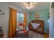 Bright Bedroom with a wooden crib, cozy chair, window with curtains, and mint green walls at 5609 Meadowood Dr, Indianapolis, IN 46224