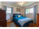 Serene bedroom featuring wood floors, windows with drapes, and a comfortable bed with matching furnishings at 5609 Meadowood Dr, Indianapolis, IN 46224