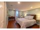 Cozy bedroom with wood floors, a window with natural light, and a comfortable armchair at 5609 Meadowood Dr, Indianapolis, IN 46224