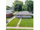 Aerial view showing well-manicured front lawn and landscaping, brick and stone facade, and mature trees at 5609 Meadowood Dr, Indianapolis, IN 46224