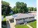 Aerial front view of charming home featuring well-manicured lawn, stone facade, and attached carport at 5609 Meadowood Dr, Indianapolis, IN 46224