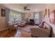 Bright living room with hardwood floors, a ceiling fan, and ample natural light from a large window at 5609 Meadowood Dr, Indianapolis, IN 46224