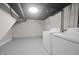 Functional basement laundry area with washer and dryer, painted floor and exposed ceiling at 5636 Crittenden Ave, Indianapolis, IN 46220