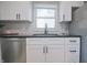 Close-up of kitchen featuring stainless steel dishwasher, black hardware and white cabinets at 5636 Crittenden Ave, Indianapolis, IN 46220