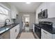 Open kitchen with stainless steel appliances, white cabinets and a view into the living room at 5636 Crittenden Ave, Indianapolis, IN 46220