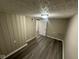 Room featuring wood-look floors, vertical siding, and neutral paint at 5704 N Keystone Ave, Indianapolis, IN 46220