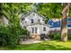 A back exterior view with a grill, patio furniture, and lush green grass at 5919 Central Ave, Indianapolis, IN 46220