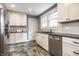 Bright kitchen with white cabinets, stainless steel dishwasher, and a stylish tile floor at 5919 Central Ave, Indianapolis, IN 46220
