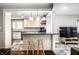 Modern kitchen with stone countertops, breakfast bar, and seamless flow into dining and living areas at 5919 Central Ave, Indianapolis, IN 46220