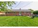 Spacious backyard featuring a well-maintained lawn, a patio area with seating, and a charming brick exterior at 5923 W 29Th Pl, Indianapolis, IN 46224