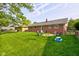 Lush backyard with a brick house, inviting patio area, fire pit and mature trees perfect for outdoor enjoyment at 5923 W 29Th Pl, Indianapolis, IN 46224