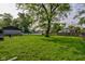 Large grassy backyard with mature trees, and a white picket fence, perfect for outdoor enjoyment at 5923 W 29Th Pl, Indianapolis, IN 46224