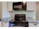 Close up of the oven and microwave with custom granite countertops at 5923 W 29Th Pl, Indianapolis, IN 46224