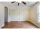 Bedroom with two closets, wood-look flooring, a ceiling fan, and one window at 602 Prospect St, Indianapolis, IN 46203