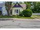 Charming yellow home featuring a well-manicured front yard, a white picket fence, and mature trees at 602 Prospect St, Indianapolis, IN 46203