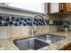 A stylish granite countertop and stainless steel sink in this home's kitchen at 602 Prospect St, Indianapolis, IN 46203