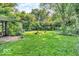 Spacious backyard with green lawn, mature trees, and pergola providing ample outdoor space for recreation and relaxation at 6235 N Temple Ave, Indianapolis, IN 46220