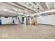 Unfinished basement featuring exposed ceiling beams, concrete floors, and a staircase at 6235 N Temple Ave, Indianapolis, IN 46220