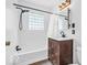 Well-lit bathroom featuring a shower-tub combo, modern vanity, and updated fixtures at 6235 N Temple Ave, Indianapolis, IN 46220