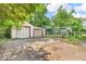 Two-car garage with worn driveway and mature trees offering potential parking and storage for homeowners at 6235 N Temple Ave, Indianapolis, IN 46220