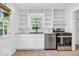 Bright eat-in kitchen features stainless steel appliances, white cabinets, and built-in shelving at 6235 N Temple Ave, Indianapolis, IN 46220