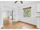 Neutral room with hardwood floors, large window, and view into another room at 6235 N Temple Ave, Indianapolis, IN 46220