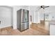 Open floor plan with hardwood floors and a modern stainless steel fridge at 6235 N Temple Ave, Indianapolis, IN 46220