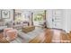 Staged room with hardwood floors, neutral furniture and a modern front door at 6235 N Temple Ave, Indianapolis, IN 46220