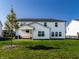 Well-maintained backyard featuring a covered patio, a lush green lawn, and a privacy fence at 628 Tess Blvd, Westfield, IN 46074