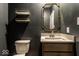 Elegant powder room with dark gray walls, modern fixtures, a vanity, decorative mirror and stylish shelving at 628 Tess Blvd, Westfield, IN 46074