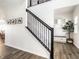 Modern staircase with iron railing, bright lighting, and views of the entrance and dining area at 628 Tess Blvd, Westfield, IN 46074