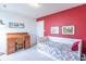 Charming bedroom featuring a bright red accent wall, a rolltop desk, and a cozy daybed at 6480 E Coal Bluff Ct, Camby, IN 46113