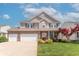 Charming two-story home featuring a well-manicured lawn and a brick and siding exterior at 6480 E Coal Bluff Ct, Camby, IN 46113