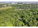 The aerial view reveals a home nestled in a lush, green, wooded landscape at 6975 Milhouse Rd, Indianapolis, IN 46221