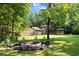 The large yard features a firepit and mature trees, perfect for entertaining at 6975 Milhouse Rd, Indianapolis, IN 46221