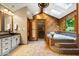 Bright and airy bathroom with skylight, stone shower, soaking tub, and natural wood accents at 6975 Milhouse Rd, Indianapolis, IN 46221