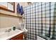Bathroom features a sink, toilet, and shower with blue and white plaid curtain at 6975 Milhouse Rd, Indianapolis, IN 46221