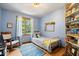 Cozy bedroom offers bright blue walls, hardwood floors, and a comfortable twin bed at 6975 Milhouse Rd, Indianapolis, IN 46221