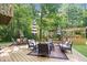 Inviting deck with stylish outdoor seating and umbrellas amidst a lush, wooded backdrop, perfect for relaxation and entertaining at 6975 Milhouse Rd, Indianapolis, IN 46221